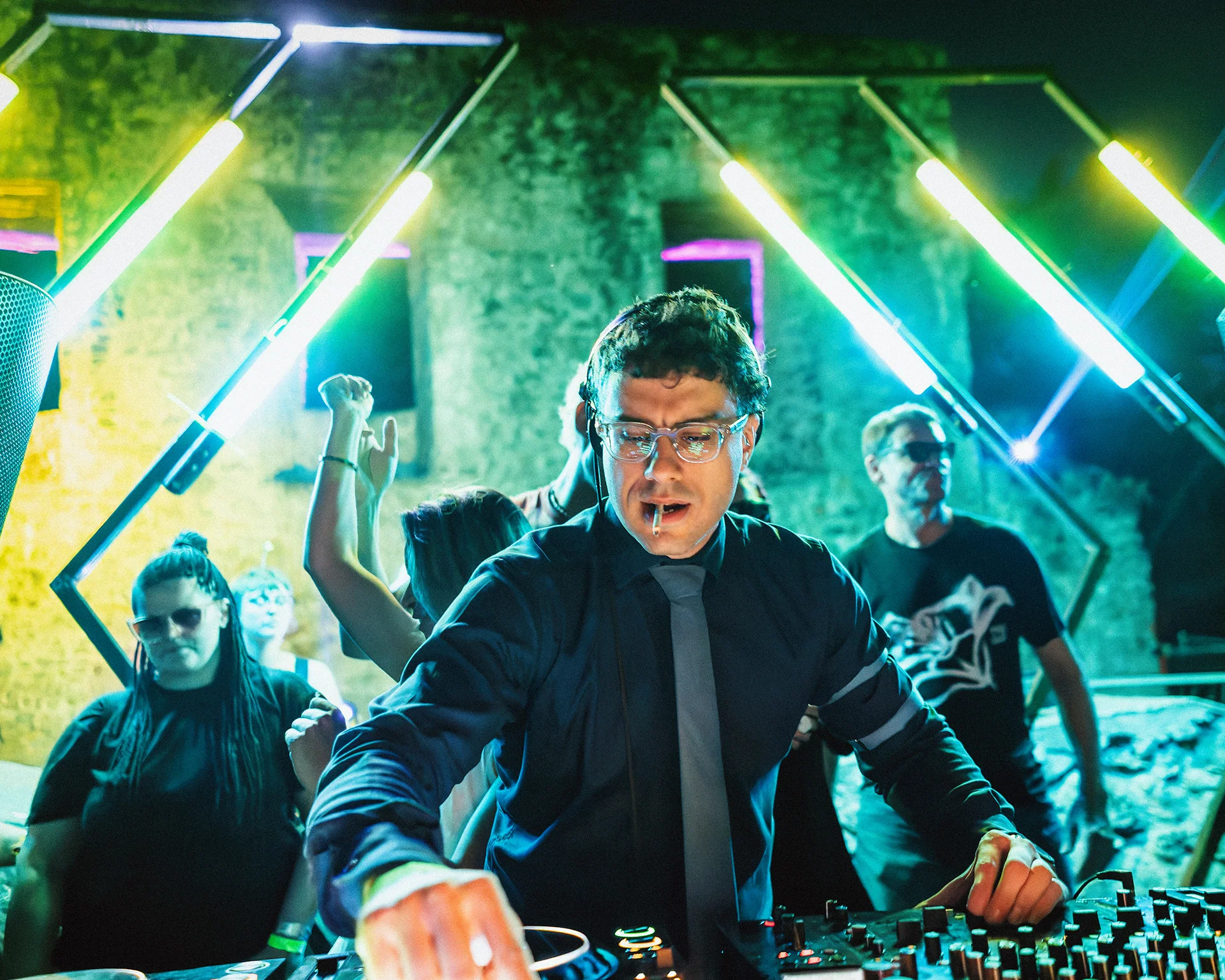 Performer moving through green beams during an energetic live show.