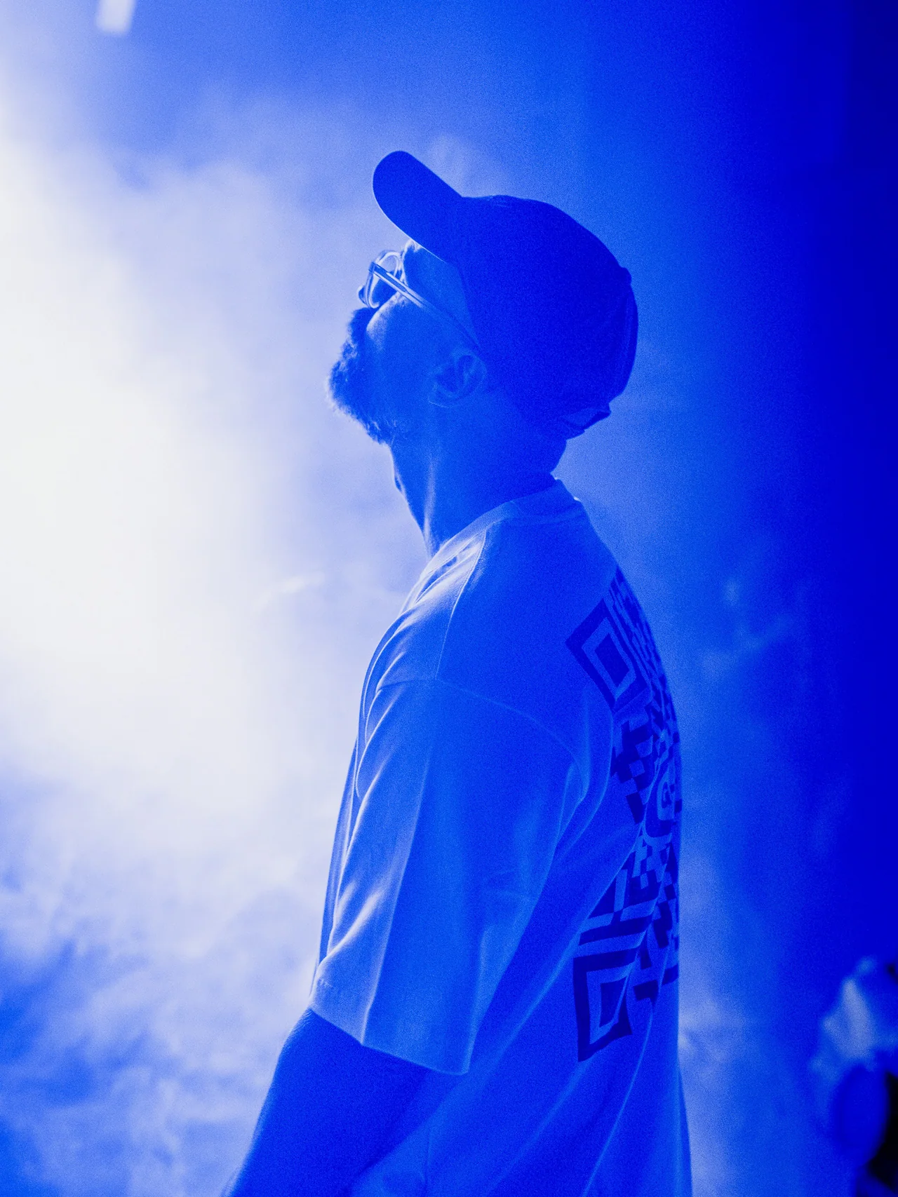 Concert guest looking upward through saturated blue light.