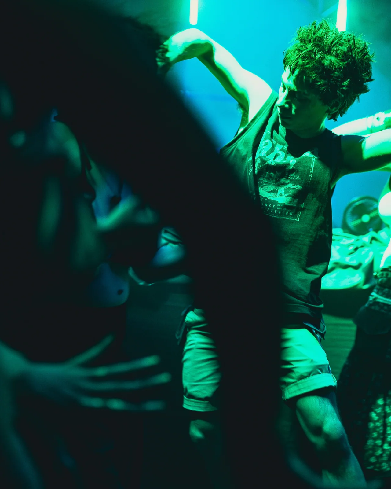 Overhead view of guests dancing in green club light.