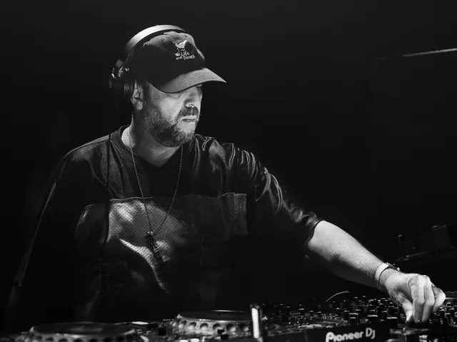 Black-and-white portrait of a DJ working at the decks.
