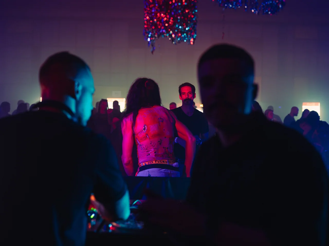 Guests watching a screen from the back of a dark venue.