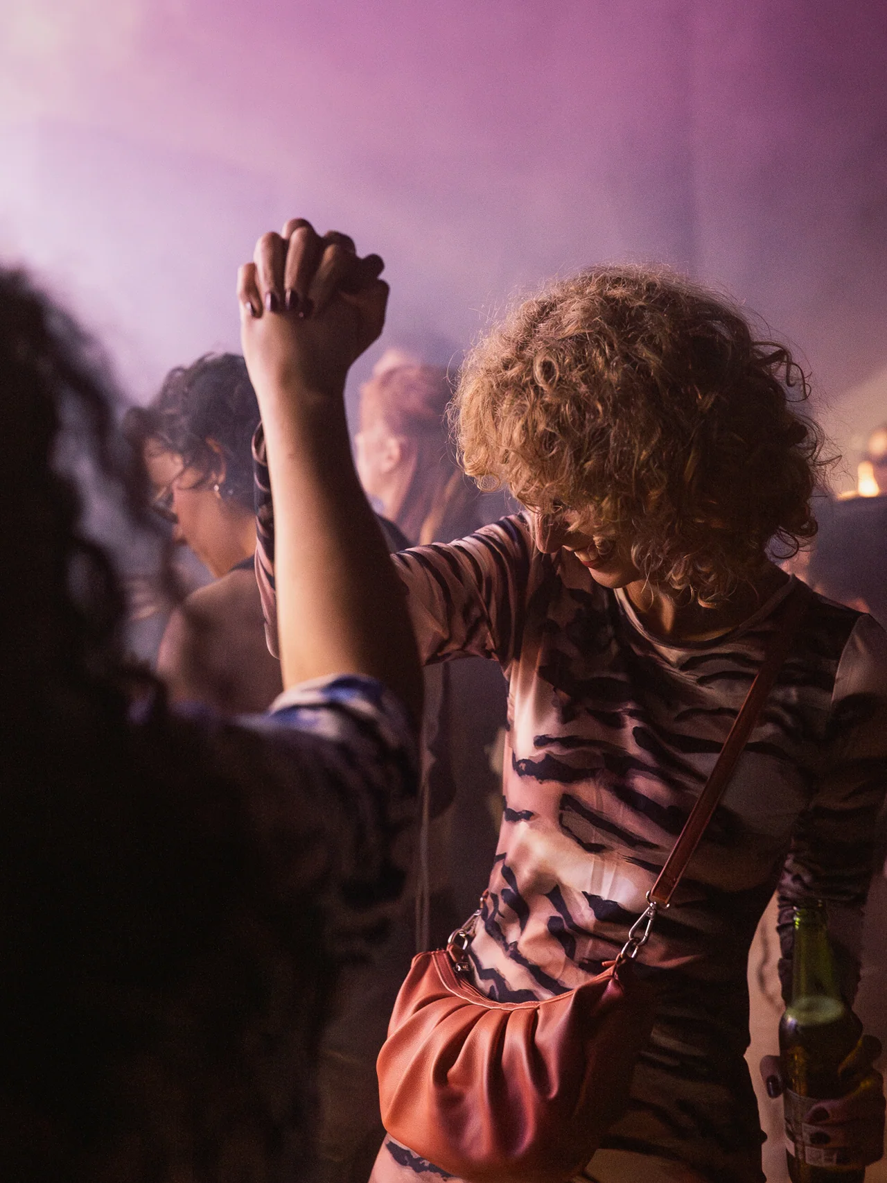 Guest dancing with one arm raised in a cloud of stage smoke.