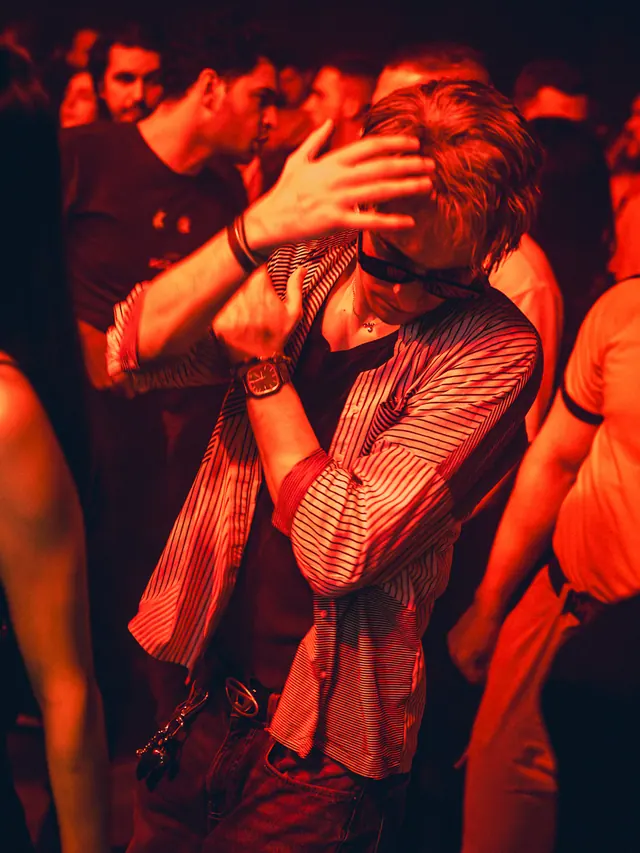 Couple embracing and kissing in the middle of a crowded club.