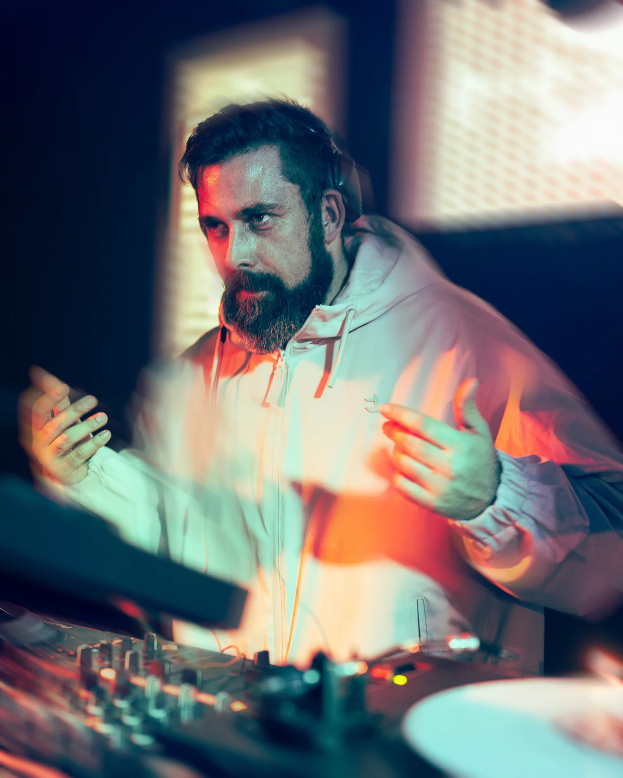 Close portrait of a bearded man in a softly lit venue.